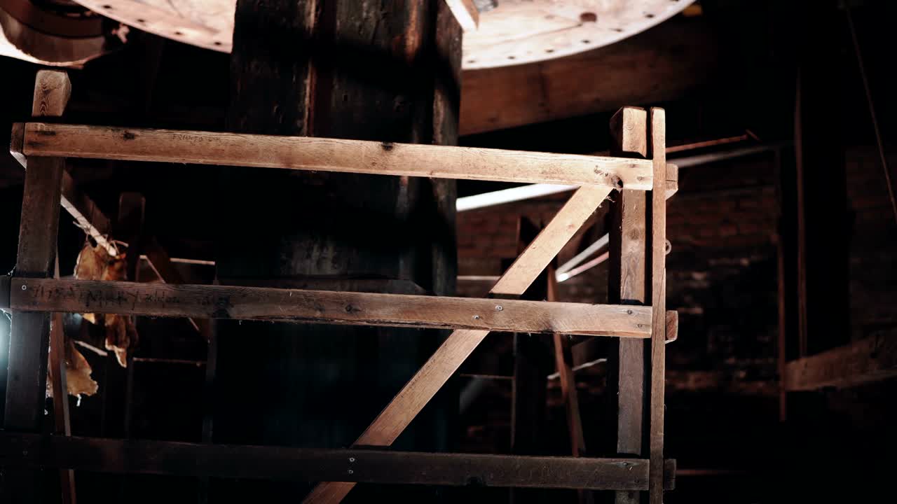 4k 전통적인 밀 메커니즘 근접 작업. 거대한 오래된 목조 네덜란드 풍차 코어 내부에서 회전. 고대 기술