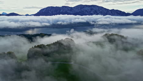 Luftaufnahme-Einer-Wunderschönen-Seeszene-Mit-Niedrigen-Wolken-Und-Berggipfeln