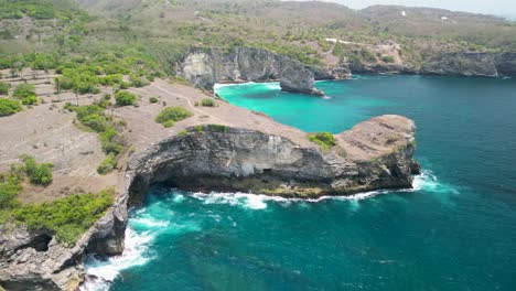 "stunning 4k drone footage of kelingking beach, nusa penida, bali. captures breathtaking cliffs, turquoise waters, and the iconic natural arch. perfect for travel, tourism