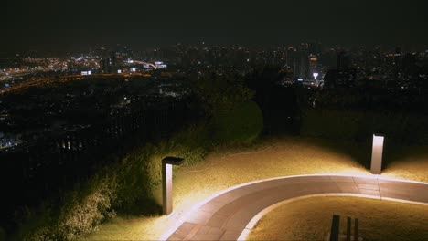 Vista-Nocturna-De-Bangkok-Desde-El-Parque-En-La-Cima-De-Una-Colina-Con-Un-Paisaje-Urbano-Brillante