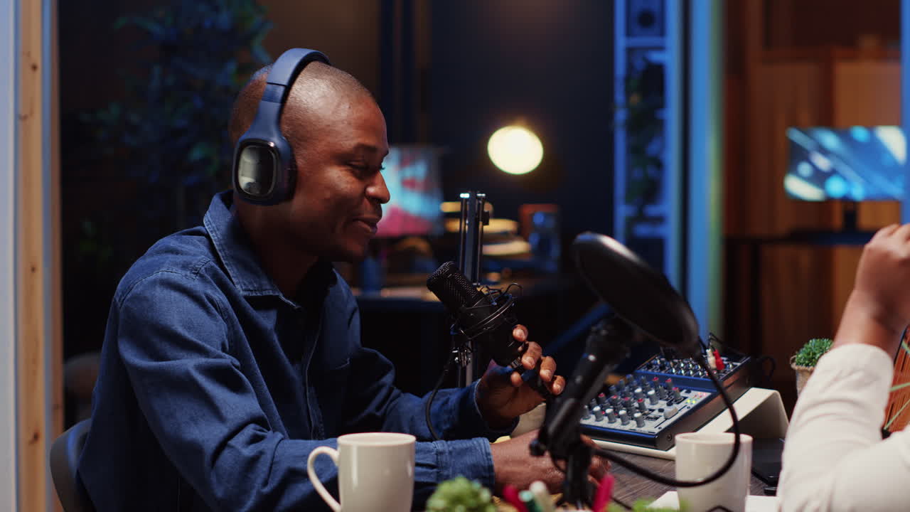 Man recording podcast, adjusting microphone to ensure optimum sound quality