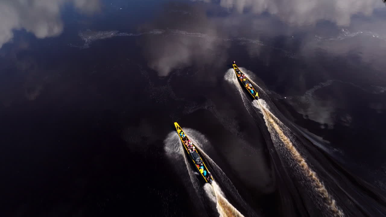Aerial View of Two Longboats with People Paddling on a Jungle River
