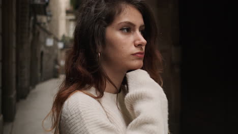 thoughtful and worried woman on narrow street in barcelona