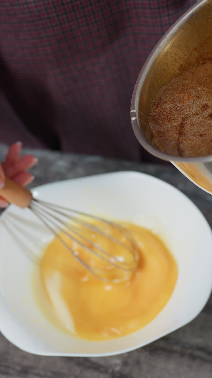 vista parcial de una persona moviendo la mezcla de huevos mientras vierte una sopa rica y sabrosa de la olla en el cuenco, las manos mezclando activamente los ingredientes en la encimera de mármol oscuro