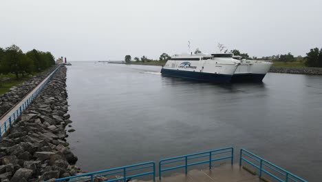 lake express ferry in the channel near the lighthouse on a rainy day