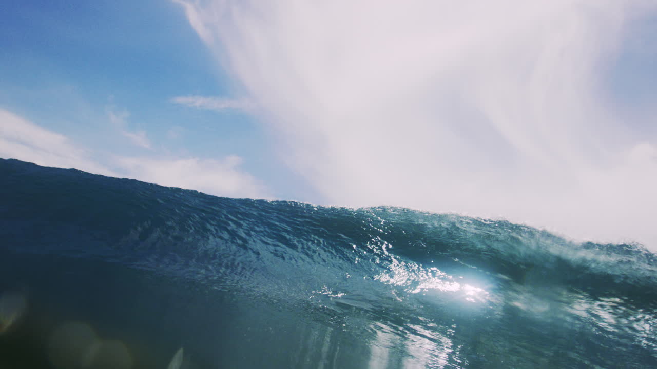 Wide low angle view of barreling wave in impact zone on reef