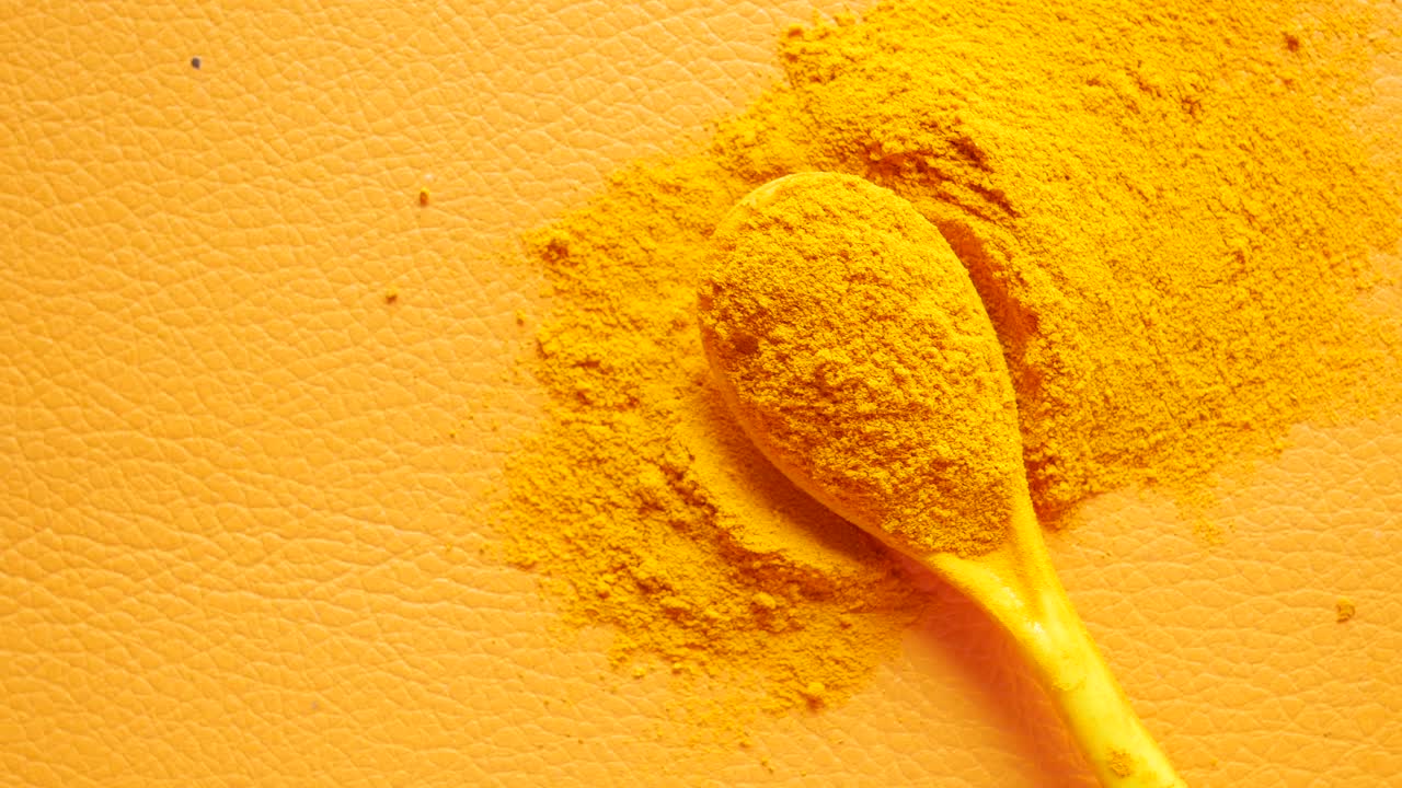Turmeric root powder on spoon ,