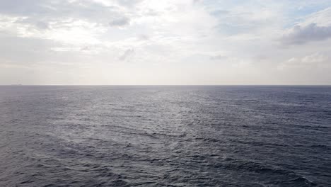 Vista-Panorámica-De-Las-Fuertes-Olas-Actuales-Que-Se-Balancean-A-Través-De-La-Superficie-Del-Océano,-El-Dron-Desciende