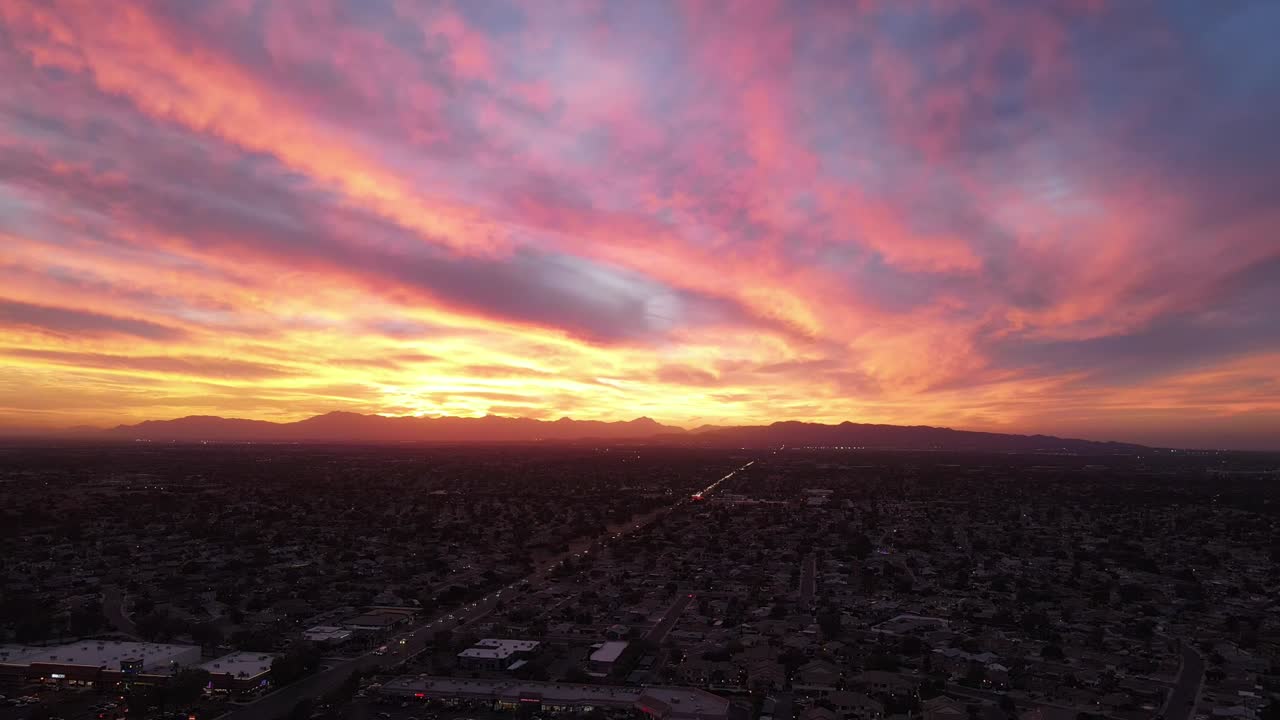 Stunning Aerial Sunset over City and Mountains