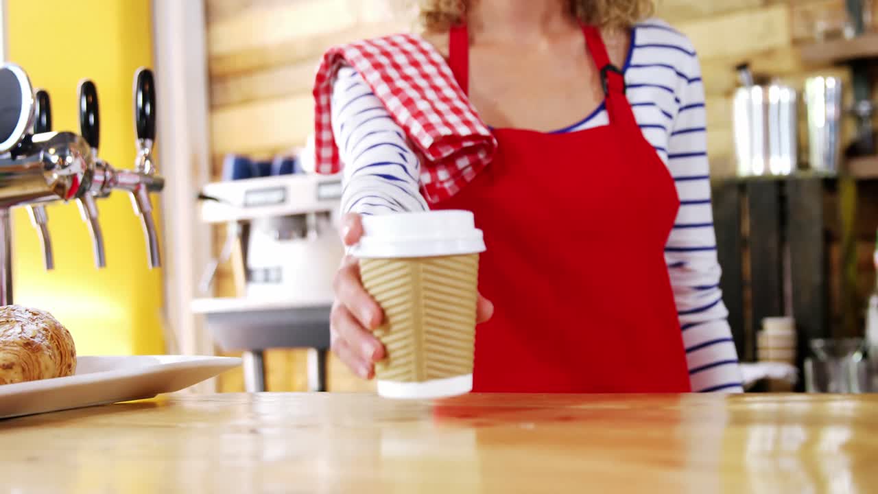 Cameriera sorridente che serve un caffè al bancone