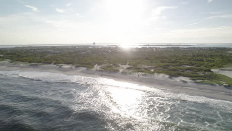 light house aerial drone move to ocean surf crashing on beach - beautiful fly down the coast