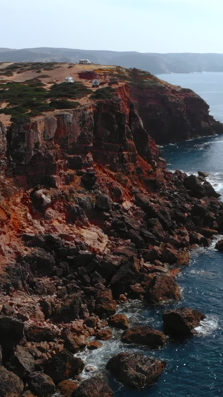 Aerial View of Rugged Red Cliffs and Crashing Ocean Waves