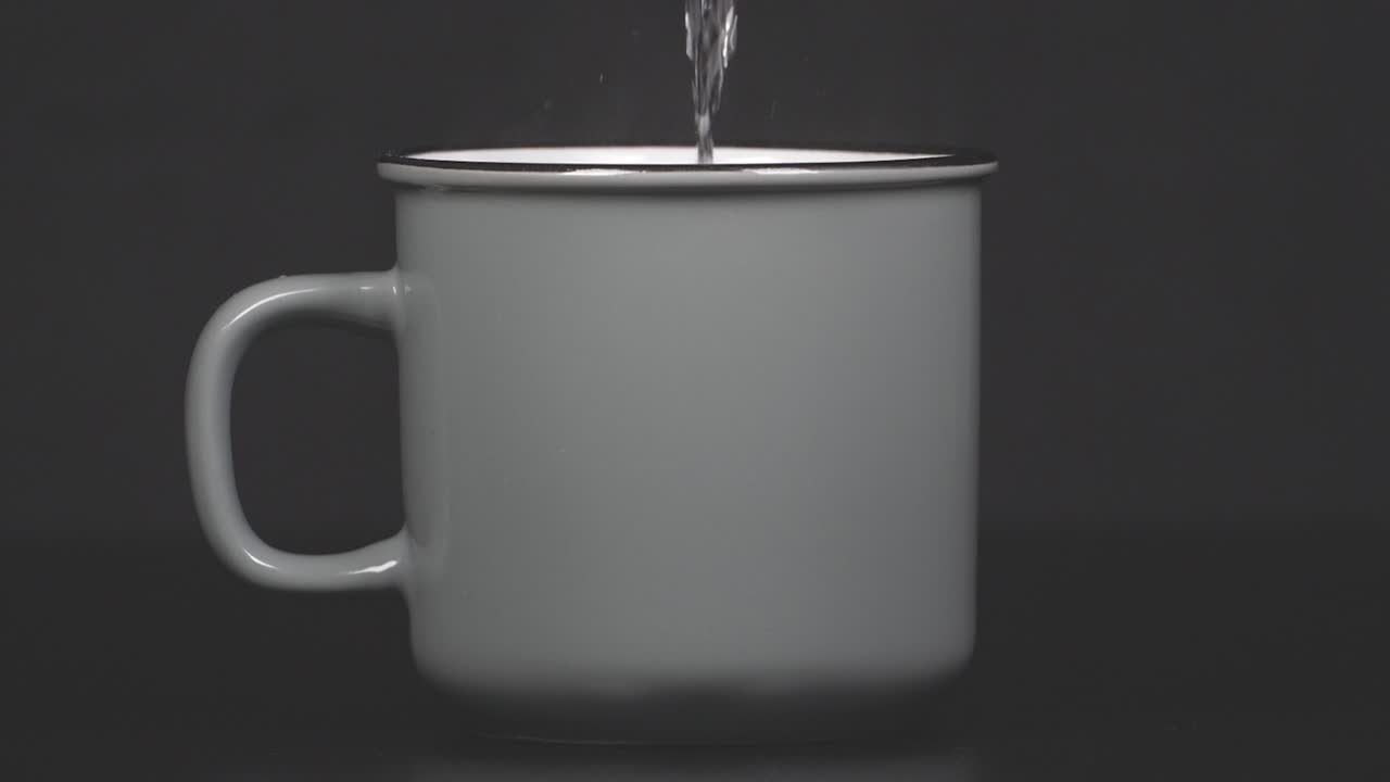 Filling cup with hot water with vapour, slow motion 4K