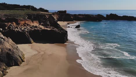 waves crashing on rocky beach near big sur, california