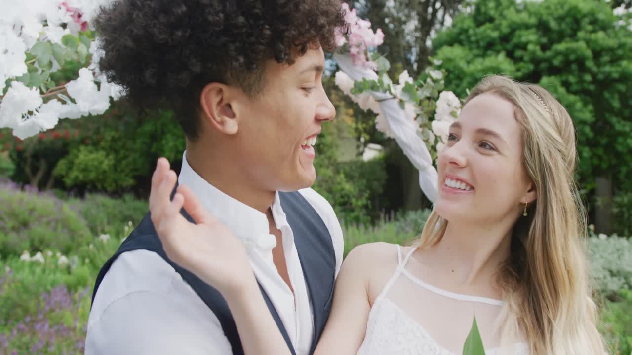 행복 한 다양 한 커플 이 결혼식 에서  ⁇ 은 날 에 포옹 하고 미소 짓고 있다