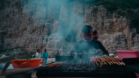 outdoor grilling of skewers with rising smoke