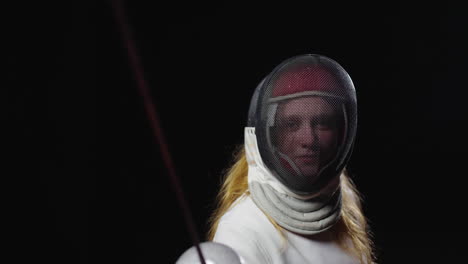 young woman wearing fencing gear and holding a sword