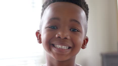 portrait of happy african american boy looking at camera and smiling in slow motion