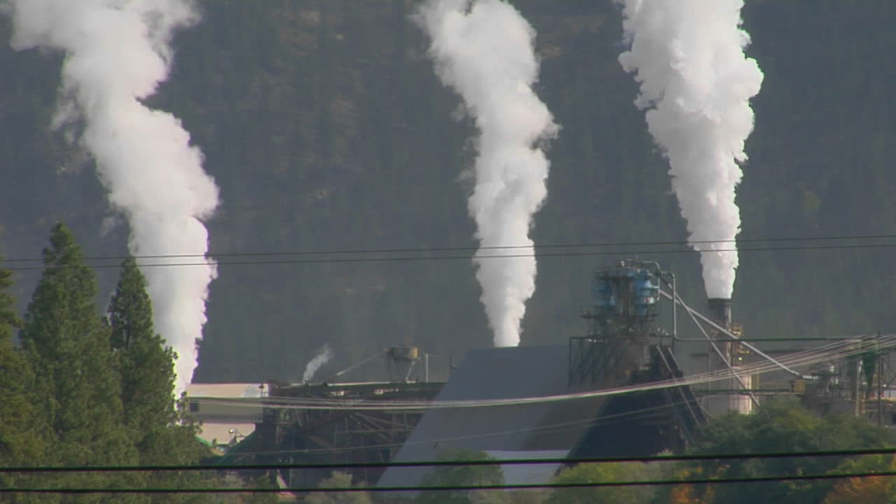 el humo sale de tres pilas de una fábrica
