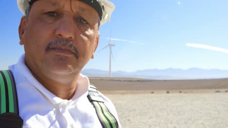 Male-engineer-standing-in-the-wind-farm-4k