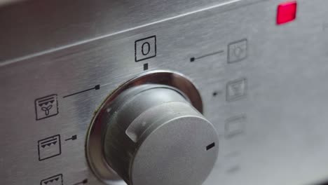 interruptor de conmutación metálico del horno de cocción de primer plano. panel frontal del horno moderno. encendiendo la estufa, horno de horneado y cambiando los modos para precalentar y cocinar la comida
