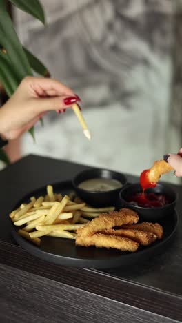 sharing a plate of fries and chicken nuggets