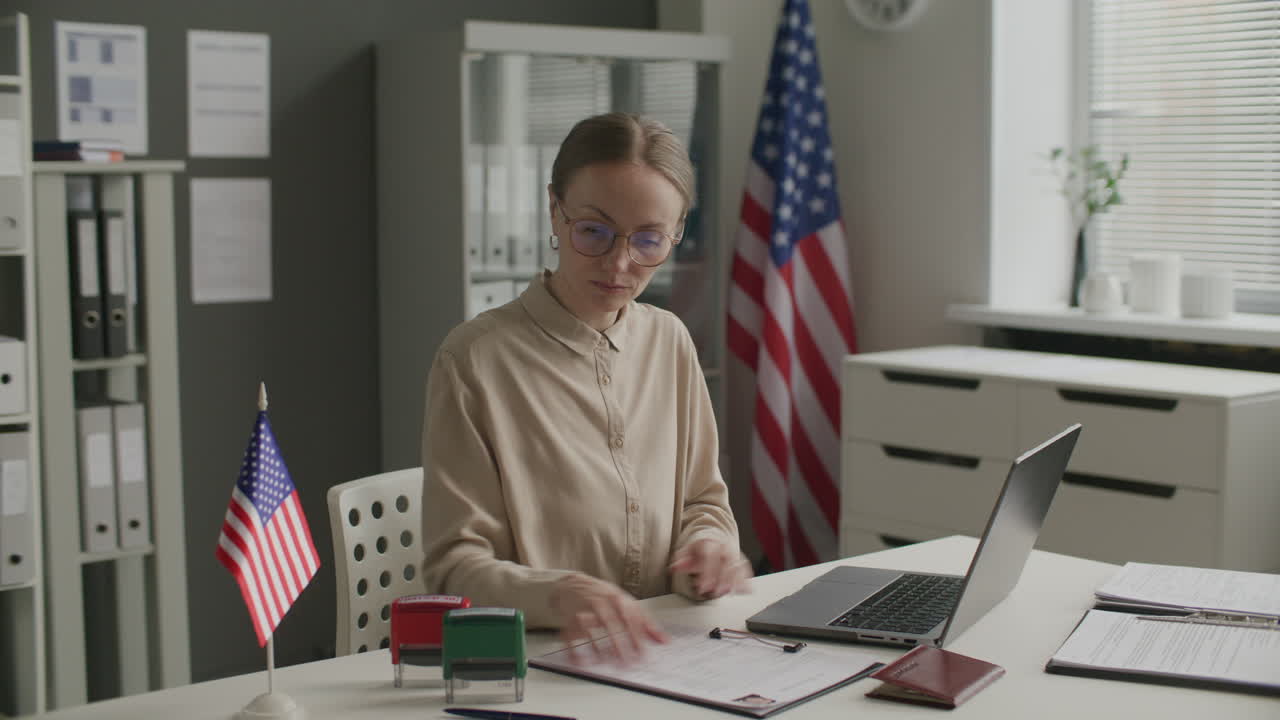 Female Visa Officer Stamping Rejection on Application Form and Using Laptop