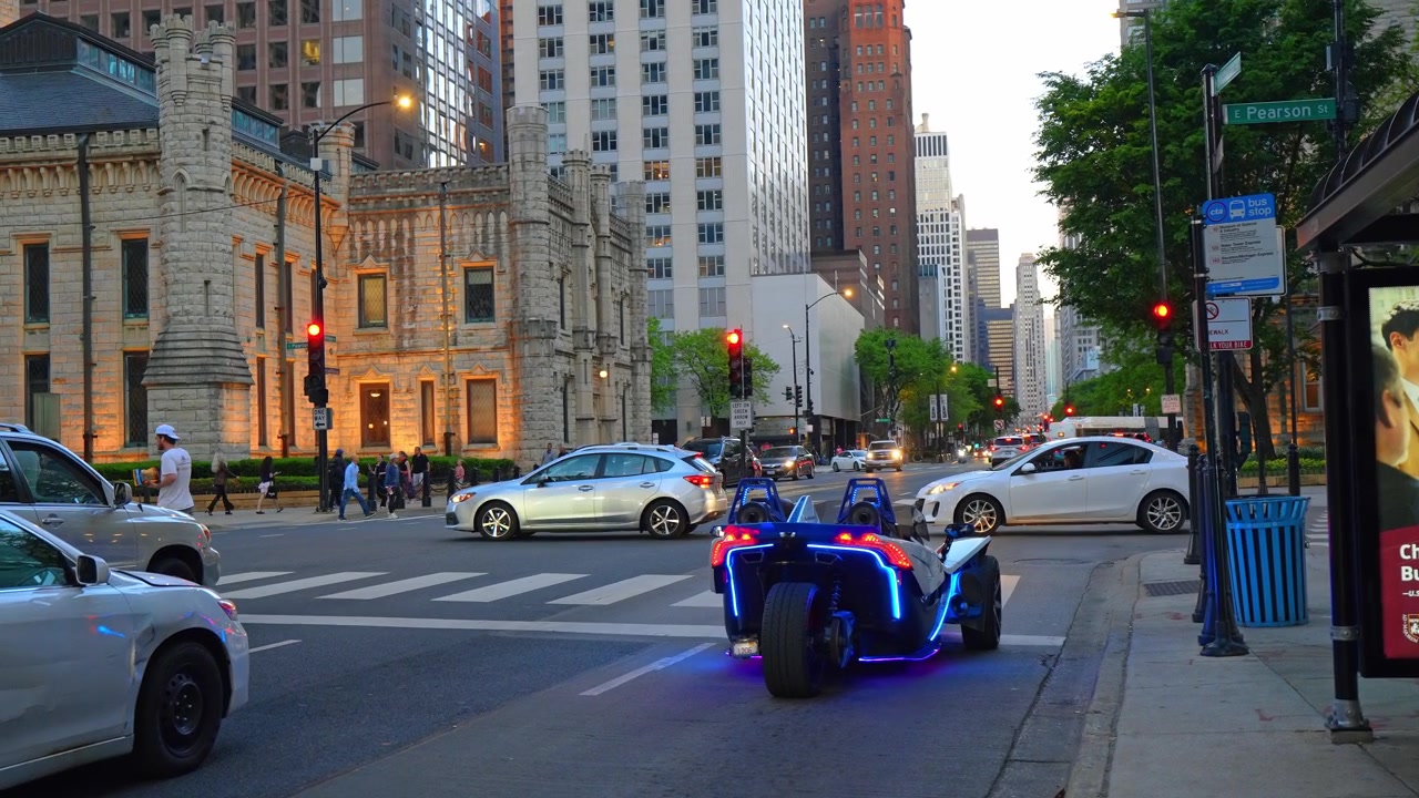 Chicago, EUA, 7 de maio de 2026: Veículo de Três Rodas com Luzes LED na Michigan Avenue, Chicago. Cena de Rua ao Anoitecer com Edifício Gótico de Pedra, Tráfego e Sinais Vermelhos