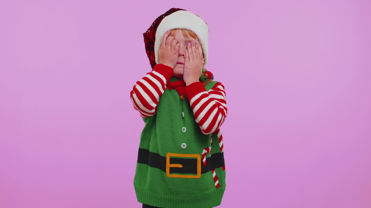 Bláznivá dívka v kostýmu Santa Clause s vyplazeným jazykem, blbnoucí a dělající legrační obličeje.