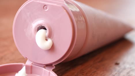 close-up of cream being squeezed from a pink tube