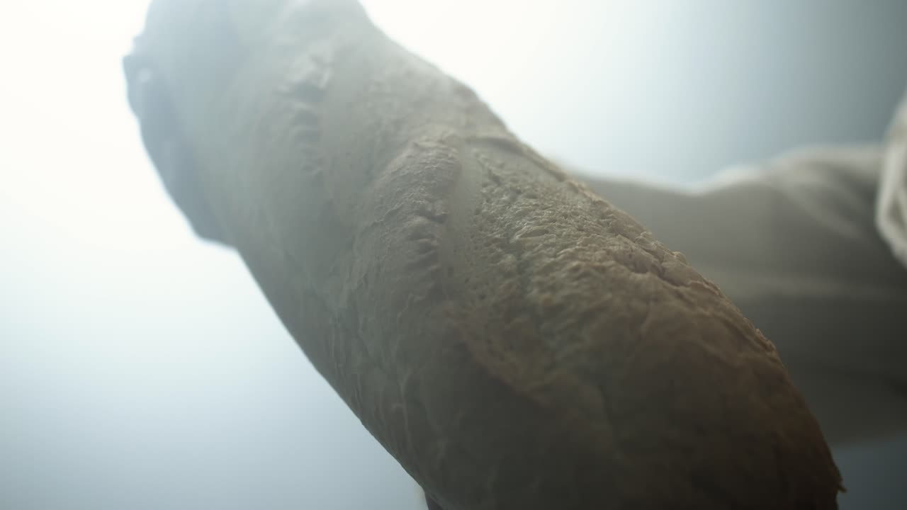 Hand Holding a Baguette