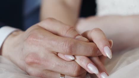 newlywed wife and husband join hands sitting together