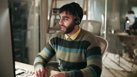 man wearing a headset working at a desk in an office