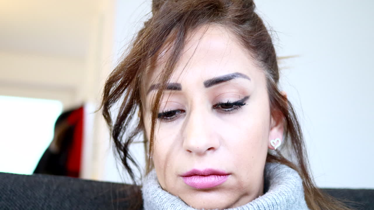 una joven del medio oriente se pone aretes de corazón y se arregla el cabello atado