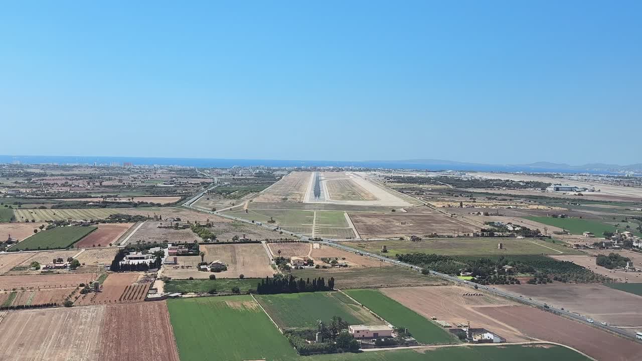 An immersive aerial view from the cockpit of a jet airplane in the final approach to Palma de Mallorca airport in a sunny summer morning