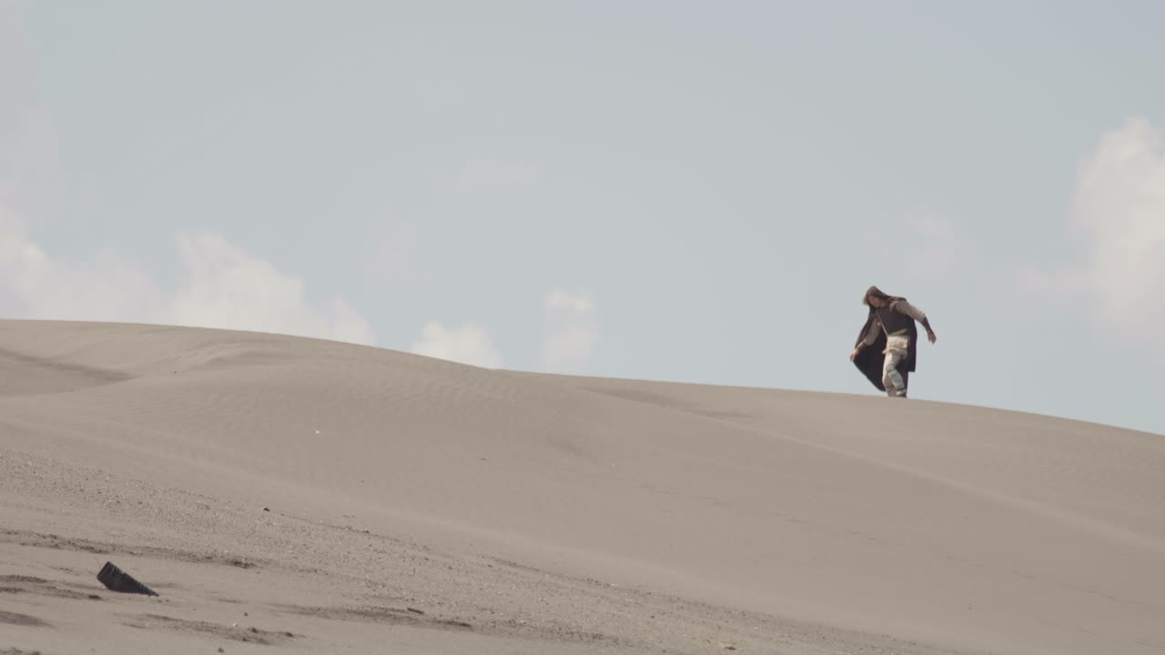 A robed figure struggles across a vast sand dune, then falls to their knees in exhaustion. Post-apocalyptic, sci-fi, or fantasy concept of despair, struggle, and survival