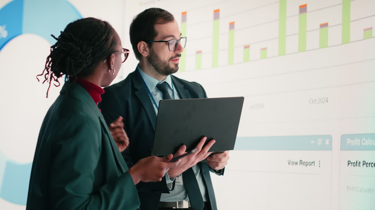 Business Colleagues Analyzing Data on Large Screen in Office