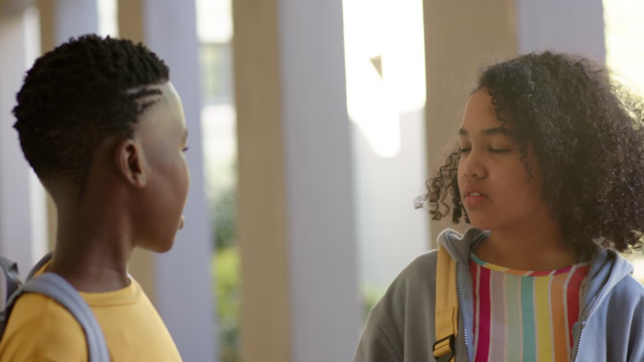 3 kids heading to porch, curly girl with yellow backpack turning toward boy entering left, greeting