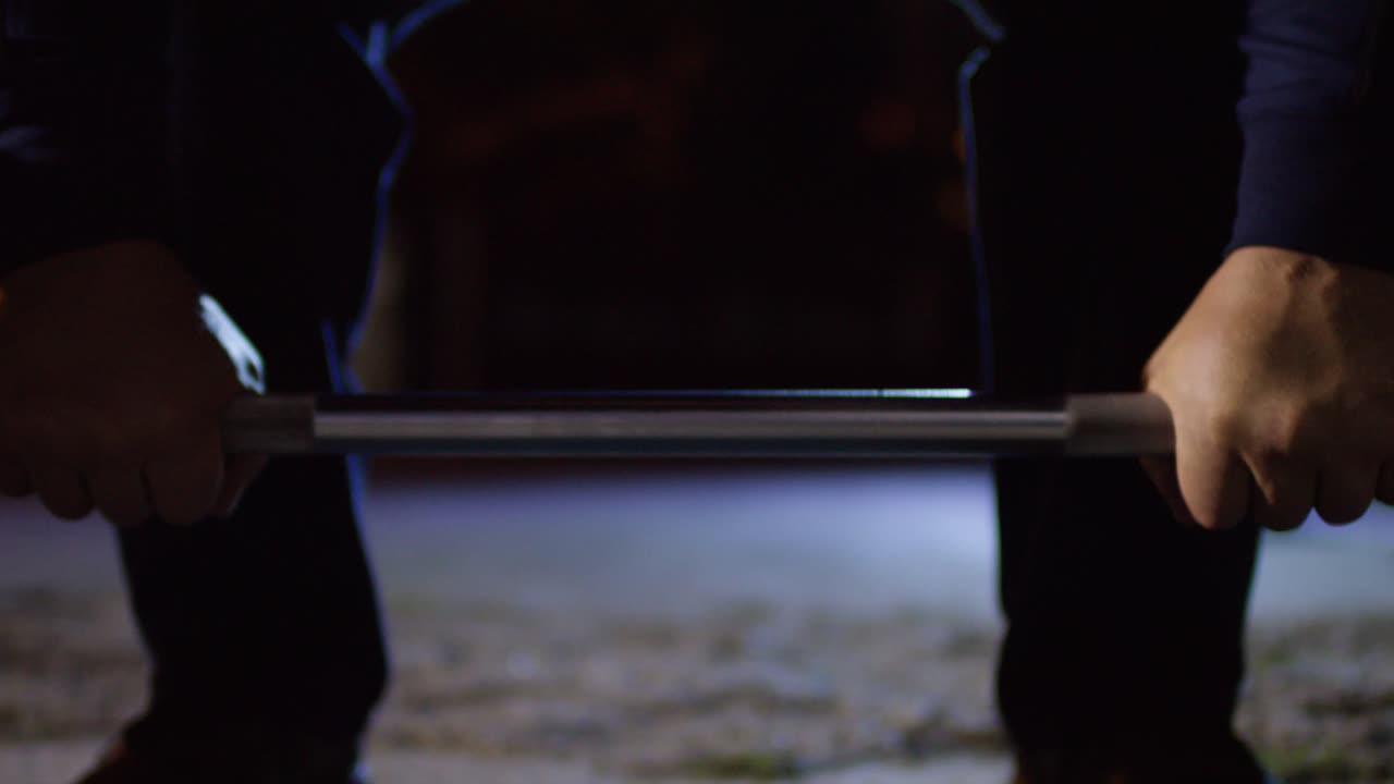 hombre levantando pesas por la noche