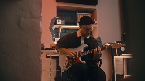 musician playing guitar in a recording studio
