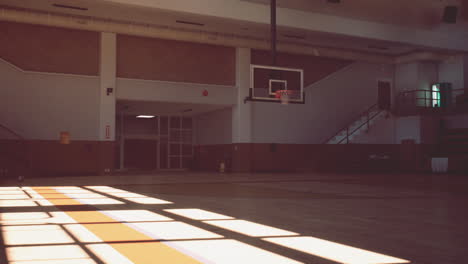 empty basketball court with wooden floor and a hoop