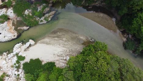 pan aérea de arriba hacia abajo sigue las vibrantes aguas verdes del río en el valle de santa marta, magdalena, colombia