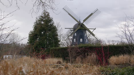historic windmill in a park landscape on a cloudy day