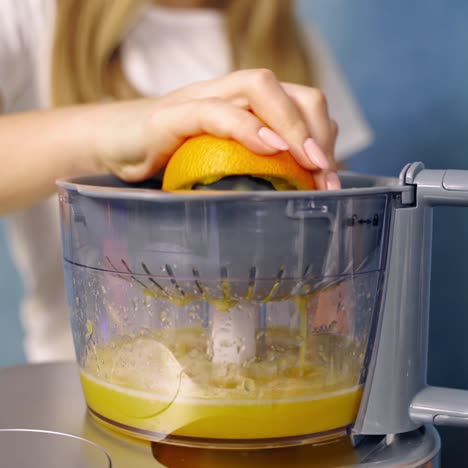 . woman making orange juice. close up of woman making juice with fresh orange