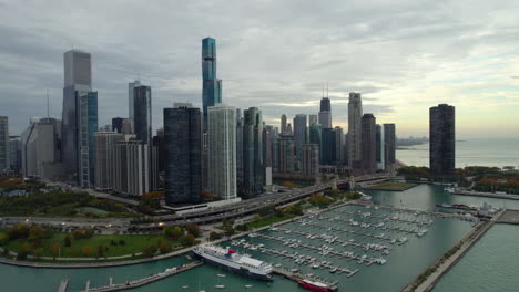 Vista-Aérea-Hacia-Atrás-Desde-La-Orilla-Del-Lago,-Nublado,-Tarde-De-Otoño-En-Chicago,-Estados-Unidos