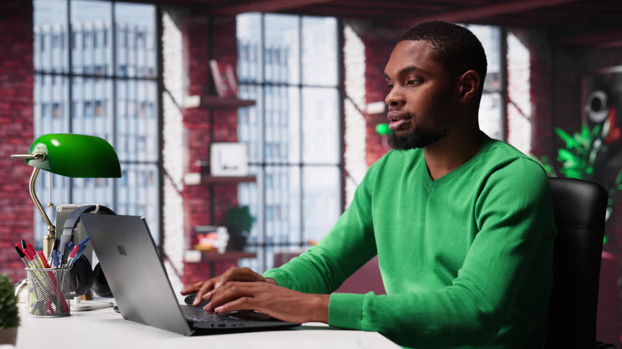 African american remote worker solving his daily freelancing tasks on laptop