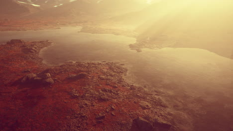 paisaje atmosférico con lago de montaña entre morrenas en clima lluvioso