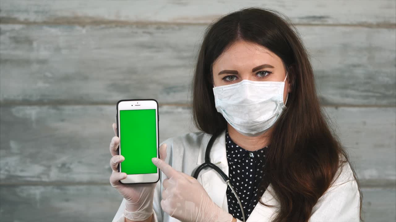 médico mostrando teléfono inteligente con pantalla verde