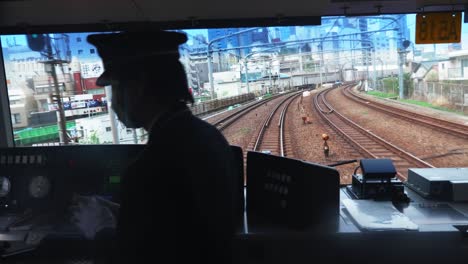 slow motion shot of loco operator moving train on railway in long journey, tokyo, japan