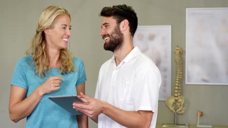 fisioterapeuta mostrando una tableta digital a una mujer